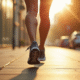 Jambes d'une personne en marche rapide avec tracker fitness en plein soleil
